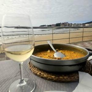 a glass of wine next to a bowl of food and a glass of white wine at Precioso chalet cerca de la playa de Samil in Vigo +6 photos