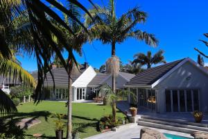 a house with palm trees in front of it at Vitry Country Estate in Gqeberha