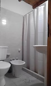 a white bathroom with a toilet and a sink at Cabañas Mai-Hue in El Bolsón +41 photos