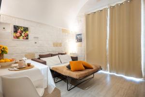 a living room with a bed and a table and chairs at Casa Roma 78 Traditional Stone House in Monopoli Center in Monopoli