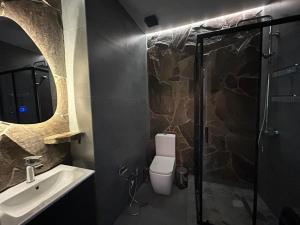 a bathroom with a toilet and a sink and a shower at Touch the Coast in Batumi