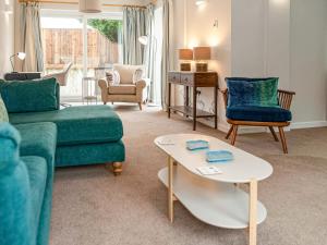 a living room with a couch and chairs and a table at Brooklands in Uplyme