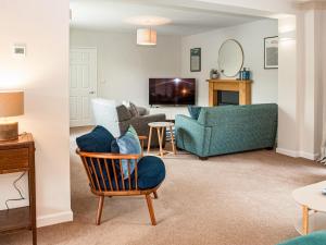 a living room with a couch and a chair at Brooklands in Uplyme