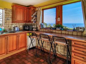a kitchen with wooden cabinets and a counter with two bar stools at Shelterstone in Elgin