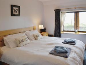 a bedroom with a large white bed with towels on it at Shelterstone in Elgin +13 photos