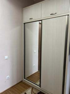 a sliding glass door in a room with a mirror at Hotel Tamo in Tsqaltubo