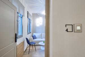 korytarz z drzwiami prowadzącymi do salonu z krzesłem w obiekcie Alba Domus 4 w Chios