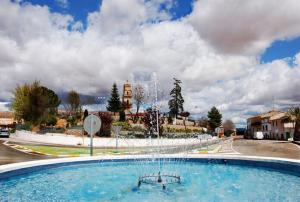 a large swimming pool with a fountain in a city at Casa El Chasquín in Caudete de las Fuentes