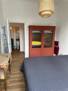 a room with a bed and a red door and a table at Appartement 16 Colette in La Bourboule