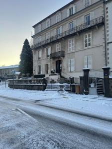 a building with snow on the ground in front of it at Appartement 16 Colette in La Bourboule