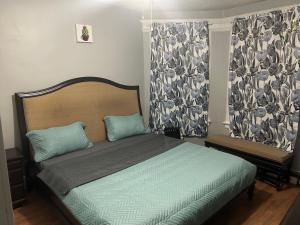 a bedroom with a bed with blue pillows and curtains at Grove#8 in Irvington
