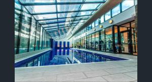 a swimming pool in a building with a glass ceiling at Banana Bliss - Spacious 2 Bedroom CBD Apartment with 2 Balconies, 2 Bathrooms & Parking Option in Melbourne