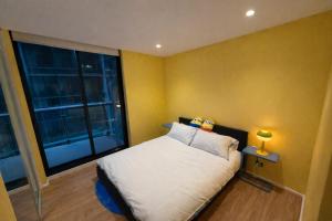 a bedroom with a bed and a large window at Banana Bliss - Spacious 2 Bedroom CBD Apartment with 2 Balconies, 2 Bathrooms & Parking Option in Melbourne +23 photos