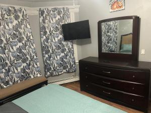 a bedroom with a dresser and a mirror at Grove#8 in Irvington