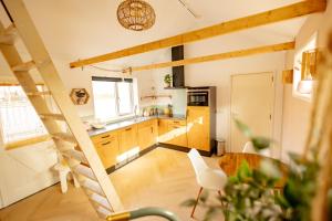 a kitchen with wooden cabinets and a staircase in a room at Sauke Jaap in Buren