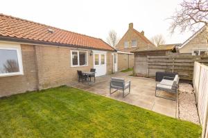 a patio with chairs and a table in a yard at Sauke Jaap in Buren