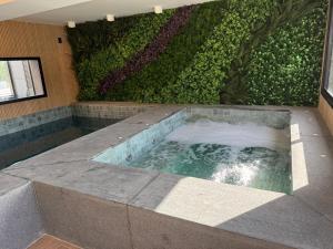 a jacuzzi tub in a room with a green wall at Luxo e Conforto 2Q Bueno- Proximo Vaca Brava 2103 in Goiânia