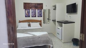 a small bedroom with a bed and a tv at Pousada irmãos Calixto in Portalegre