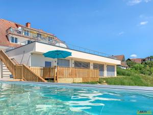 a house with a swimming pool and an umbrella at Das Holland in Kapfenstein