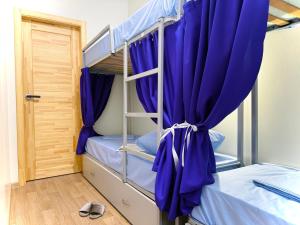 ein Schlafzimmer mit zwei Etagenbetten und lila Vorhängen in der Unterkunft Kust Hostel in Kiew