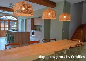 a kitchen and dining room with a large wooden table at Maison d'exception, 14 personnes, piscine, vue Pyrénées in Sévignacq-Meyracq