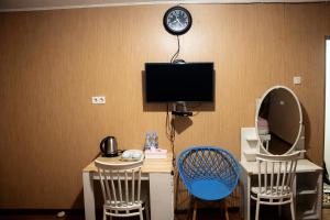 a room with a desk with a monitor and two chairs at Fideluna Beach Bungalow in Insyurifuri