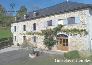 a large stone house with a large wooden door at Maison d'exception, 14 personnes, piscine, vue Pyrénées in Sévignacq-Meyracq