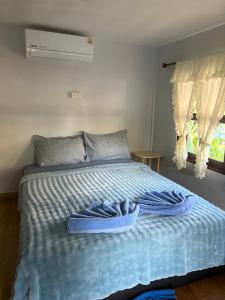 a bed with blue towels on it with a window at Pyramid Bangalow in Ban Laem Sai