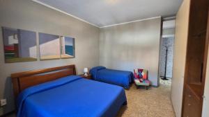 a bedroom with two blue beds in a room at Terry House in Sirmione
