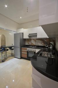 a kitchen with white cabinets and a black counter top at Modern Design Villa Private Pool Marrakech in Marrakesh
