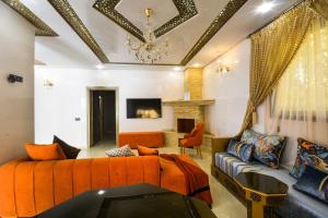 a living room with an orange bed and a couch at Modern Design Villa Private Pool Marrakech in Marrakesh