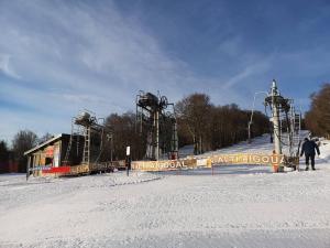 a person standing in the snow next to a ski lift at Tiny Mirador à la Ferme in Tréves