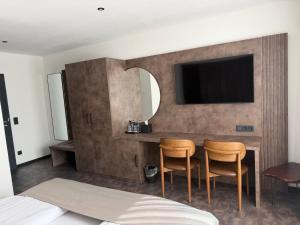 a bedroom with a table with two chairs and a tv at JG Hotel & Restaurant Antoniergasse in Memmingen