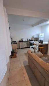 a living room with a couch and a kitchen at Casa Vila Mar Guesthouse in Guaratuba +11 photos