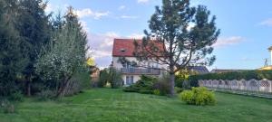 a white house with a red roof and a yard at Apartament u Buki Zator, Skawina, Kraków in Pozowice