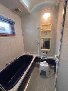 a bathroom with a tub and a toilet in it at リトリート奥入瀬屋 in Towada