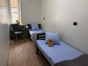 Ein Teddybär sitzt auf einem Bett in einem Zimmer in der Unterkunft Kust Hostel in Kiew