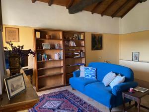 a living room with a blue couch and book shelves at Casa Rosmarino Malgrate in Filetto