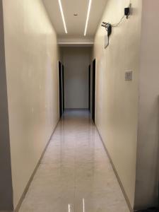 a hallway with doors and a tile floor at Hotel Atithi Lodging in Pimpalgaon