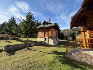 a house in a field with a tree in front of it at Evergreen Sokolina in Rača