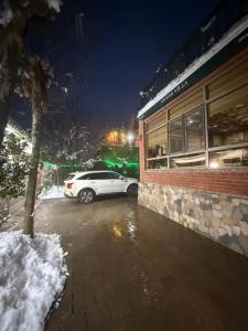 a car parked outside of a building in the snow at Villa lux in Qusar