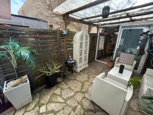 a patio with two chairs and a pergola at Studio sur agde, avec cour, parking et spa en option à 30e par jour in Agde