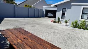 ein Hinterhof mit einer Holzbank und einem Haus in der Unterkunft Flip-Flops studio in Hermanus