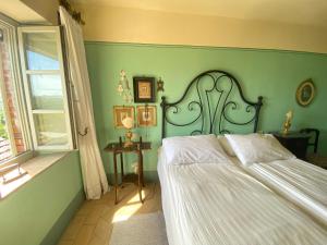 a green bedroom with a bed and a window at Casa Rosmarino Malgrate in Filetto