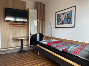 a room with a bed and a flat screen tv at Pension Hammoor in Hammoor