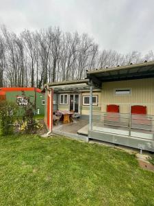 a house with a deck with a table and chairs at Gite Raphael in Bourbourg