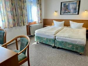 a hotel room with a bed and a table and chairs at Benz Café & Pension in Blankenburg