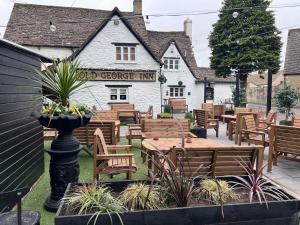a restaurant with wooden tables and chairs in a yard at The loft in Cirencester