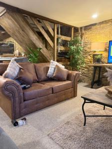 a living room with a brown couch and a table at The loft in Cirencester