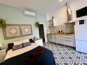 a bedroom with a large bed and a kitchen at INT Studio totalmente equipado, 15' de BCN centro 8' playa in Sant Adria de Besos